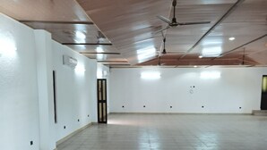 A spacious, empty room with a high ceiling, recessed lighting, and a ceiling fan. - Relais de l'Atakora  (Kpalimé)