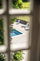 Uma área de piscina com espreguiçadeiras e um muro de pedra.