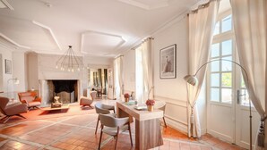 A spacious living room with a fireplace, modern furniture, and large windows.