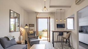 Una sala de estar moderna con sofá, una mesa de centro y un comedor con televisor.