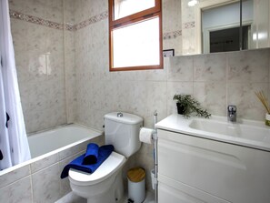 Bathroom features a modern design with a white toilet, sink, and decorative tile pattern.