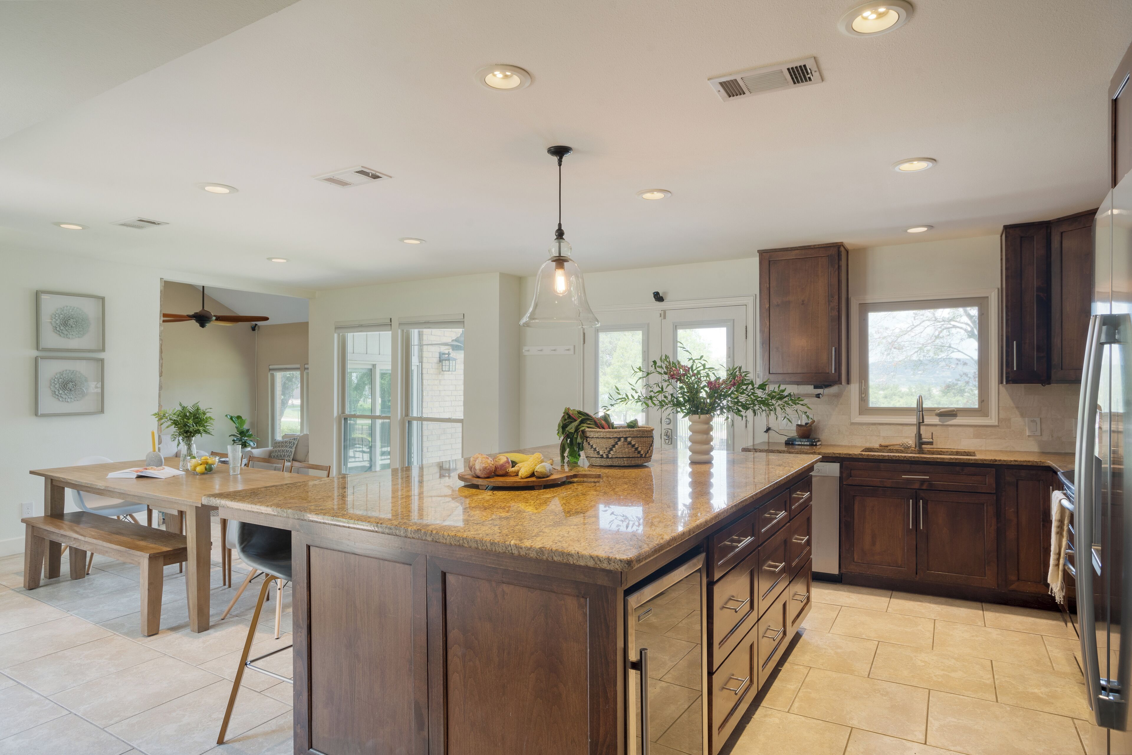 A spacious kitchen with a large island, wooden cabinets, and modern appliances.