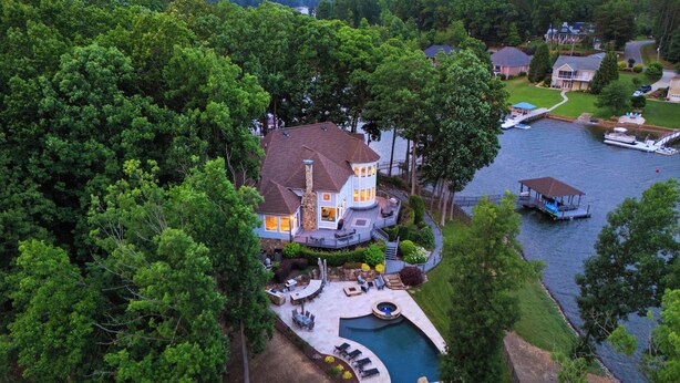 A large house with a swimming pool, surrounded by dense trees and a lake. - Private Dock, Pool + HotTub, Game Room, Firepit | | Paradise Pointe by AvantStay (Sherrills Ford)
