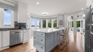 A modern kitchen with white cabinetry, a stainless steel dishwasher, and a large island with drawers. - Private Dock, Pool + HotTub, Game Room, Firepit | | Paradise Pointe by AvantStay (Sherrills Ford)