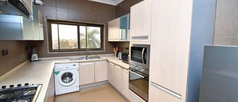 Een microgolfoven, een oven, een kookplaat, kookgerei, borden en bestek