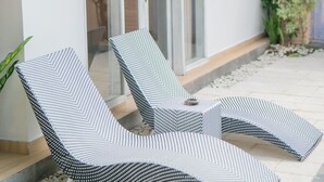Un espace extérieur moderne, aménagé avec deux fauteuils confortables et un auvent.