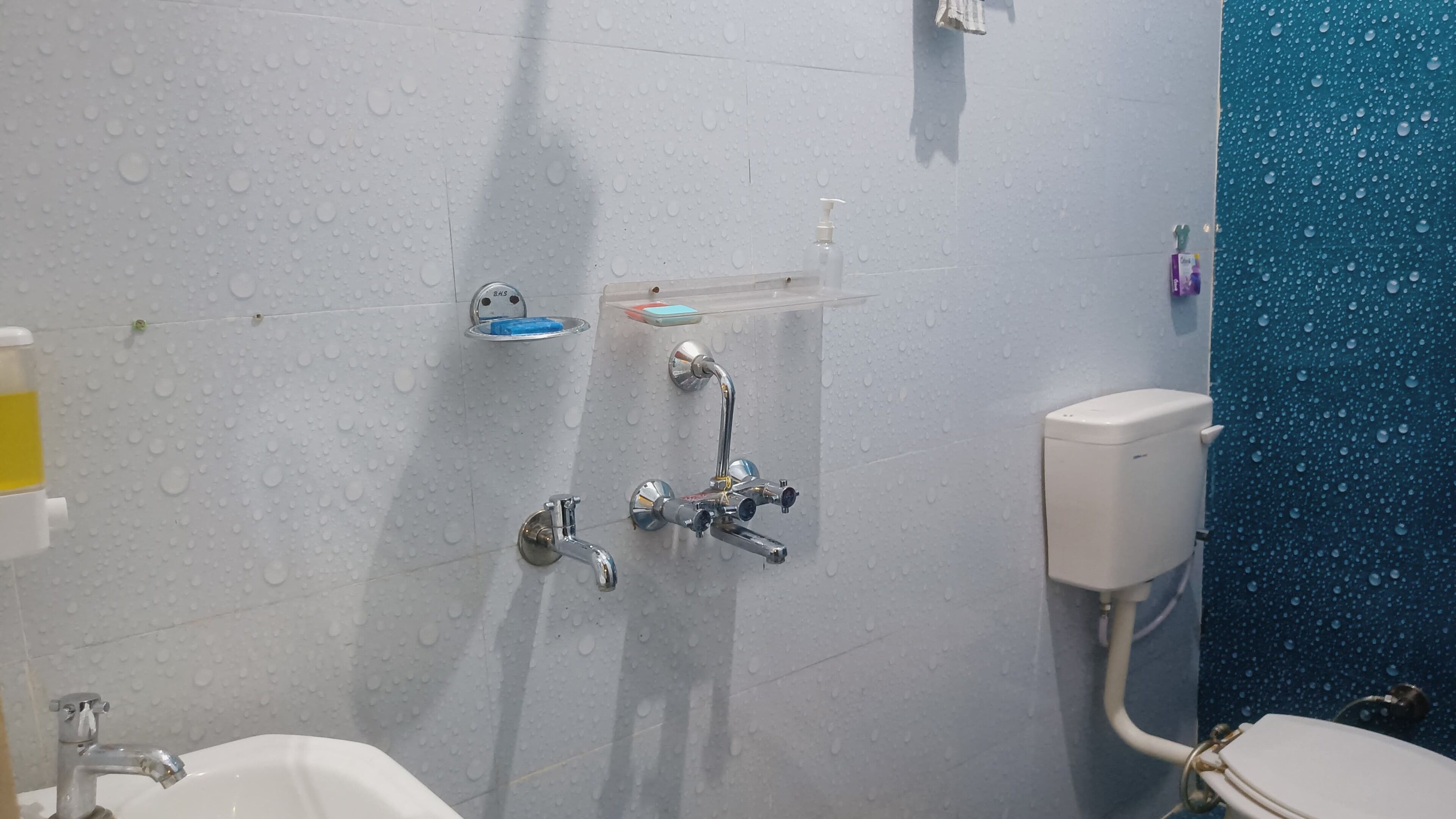 A bathroom with a white sink, a toilet, and a shower area.