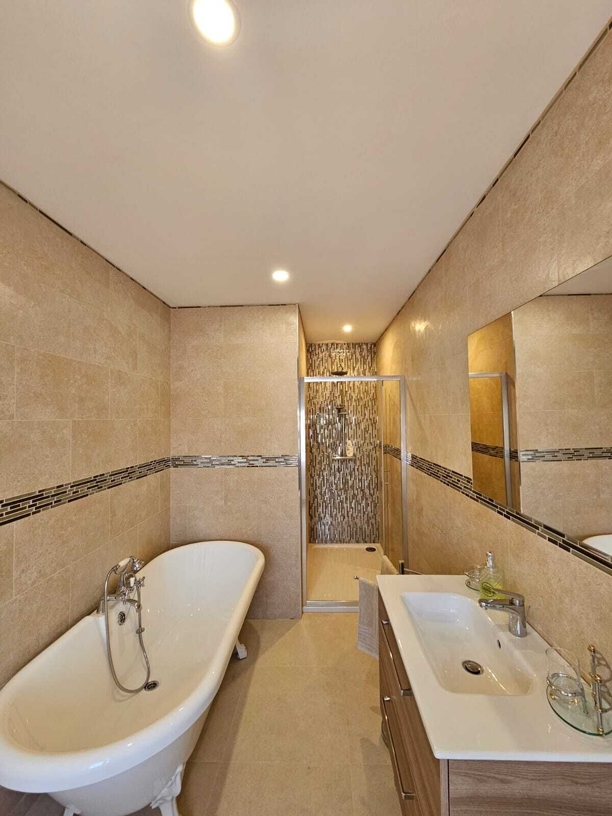 Une salle de bain moderne avec une baignoire sur pieds, un espace douche et un meuble-lavabo avec un miroir.