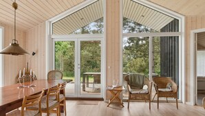 A spacious dining area with a wooden table and chairs, large windows, and a view of the outdoors. - "Vojdan" - 600m from the sea by Interhome (Fårevejle)