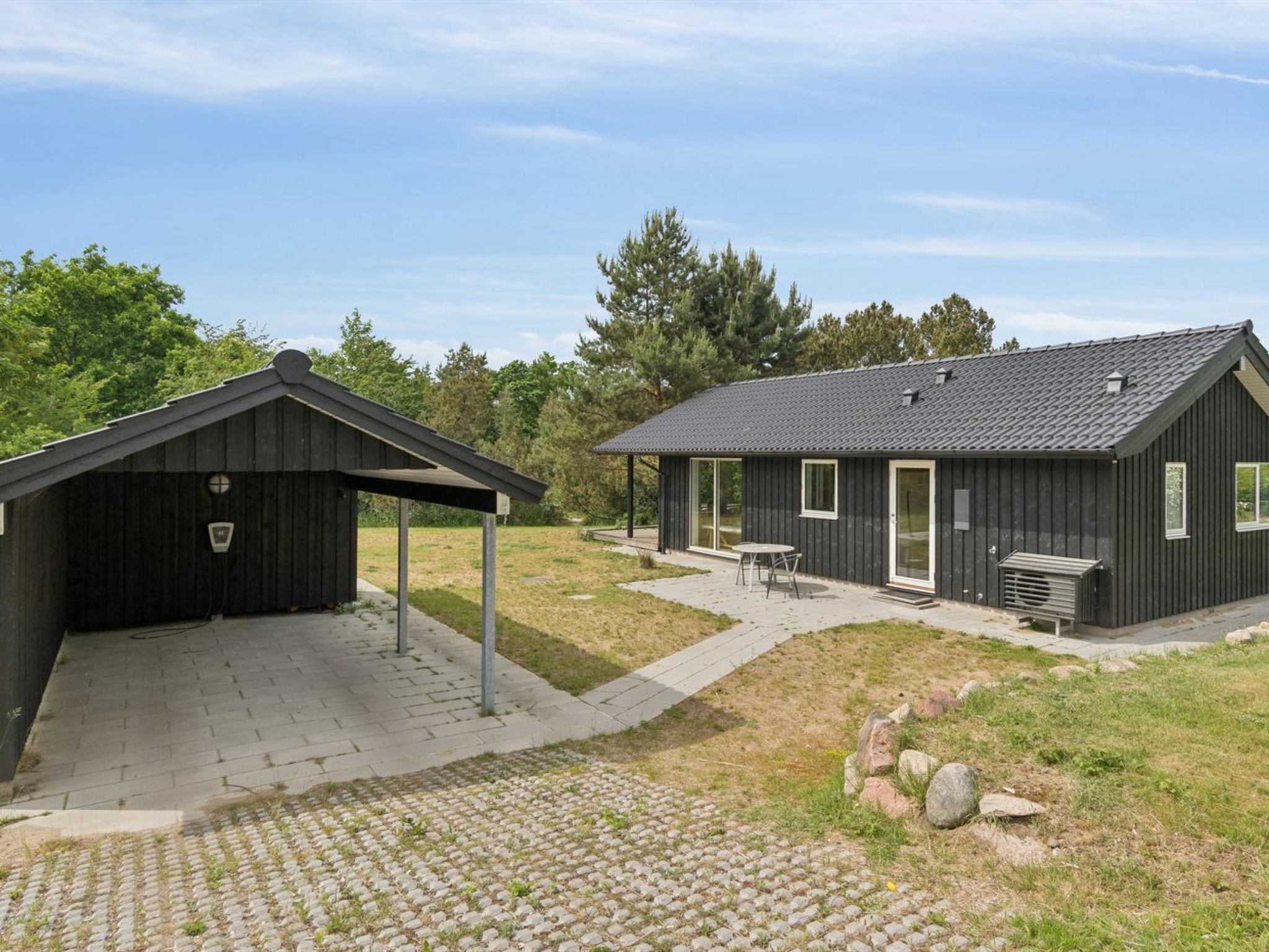 En modern byggnad med ett takförsett utomhusområde för sittplatser och en uteplats.
