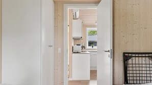 A room with two beds, a wooden ceiling, and a view into a kitchen area. - "Vojdan" - 600m from the sea by Interhome (Fårevejle)