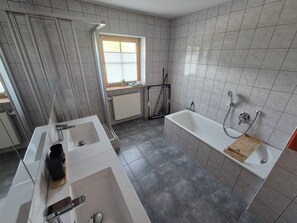 Ein modernes Badezimmer mit Badewanne, Dusche und Waschbecken.