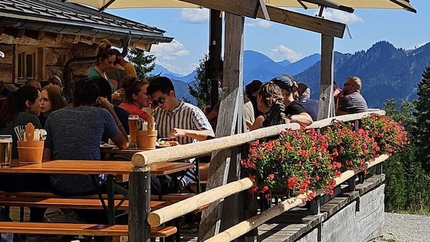 A restaurant with outdoor seating overlooking mountains.