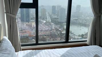 Ein Hotelzimmer mit großem Fenster und Blick auf die Stadt.