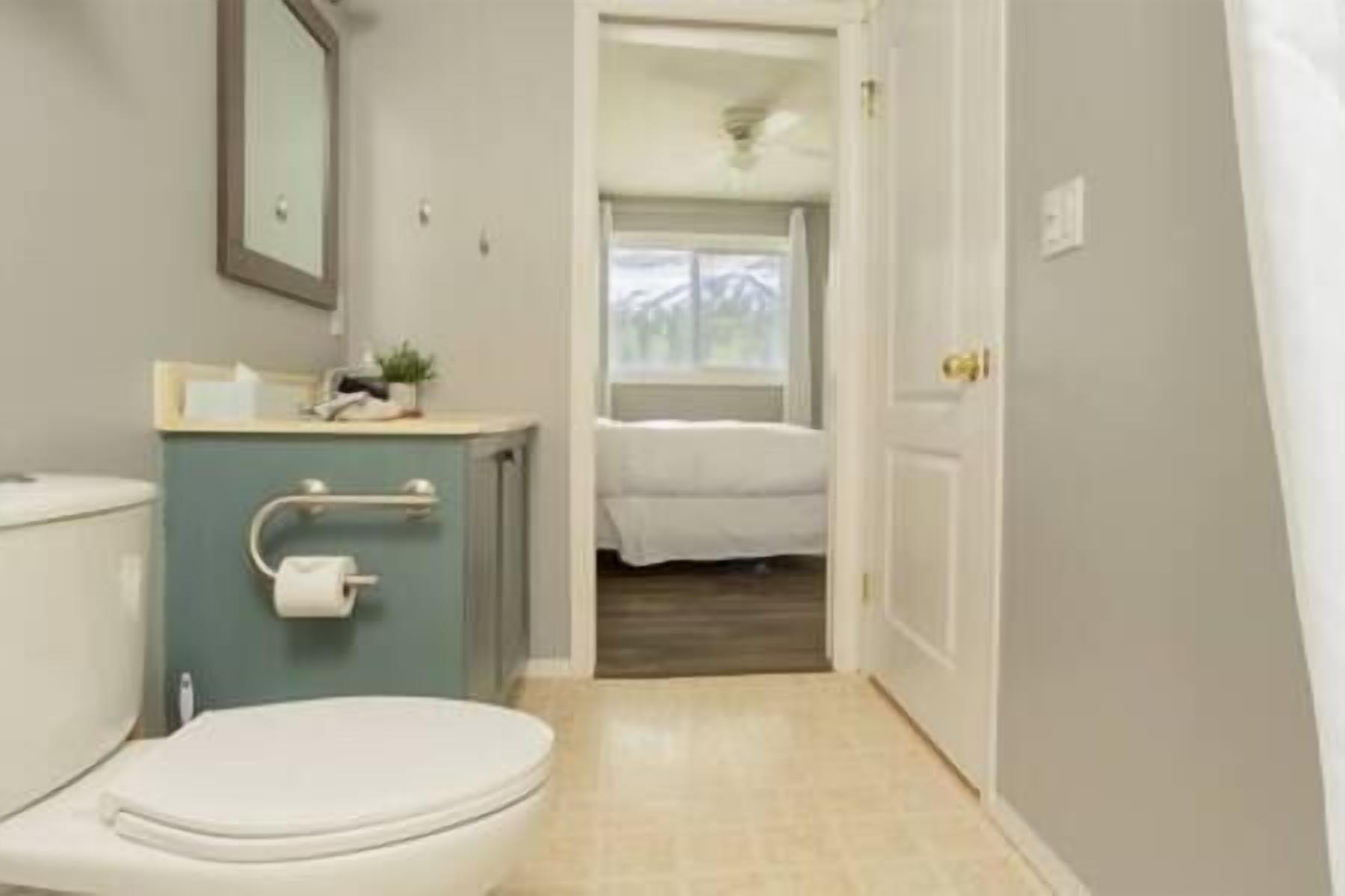 Une salle de bain comprenant des toilettes, un lavabo et un espace douche.