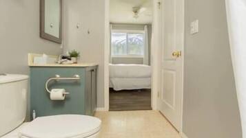 Une salle de bain comprenant des toilettes, un lavabo et un espace douche.