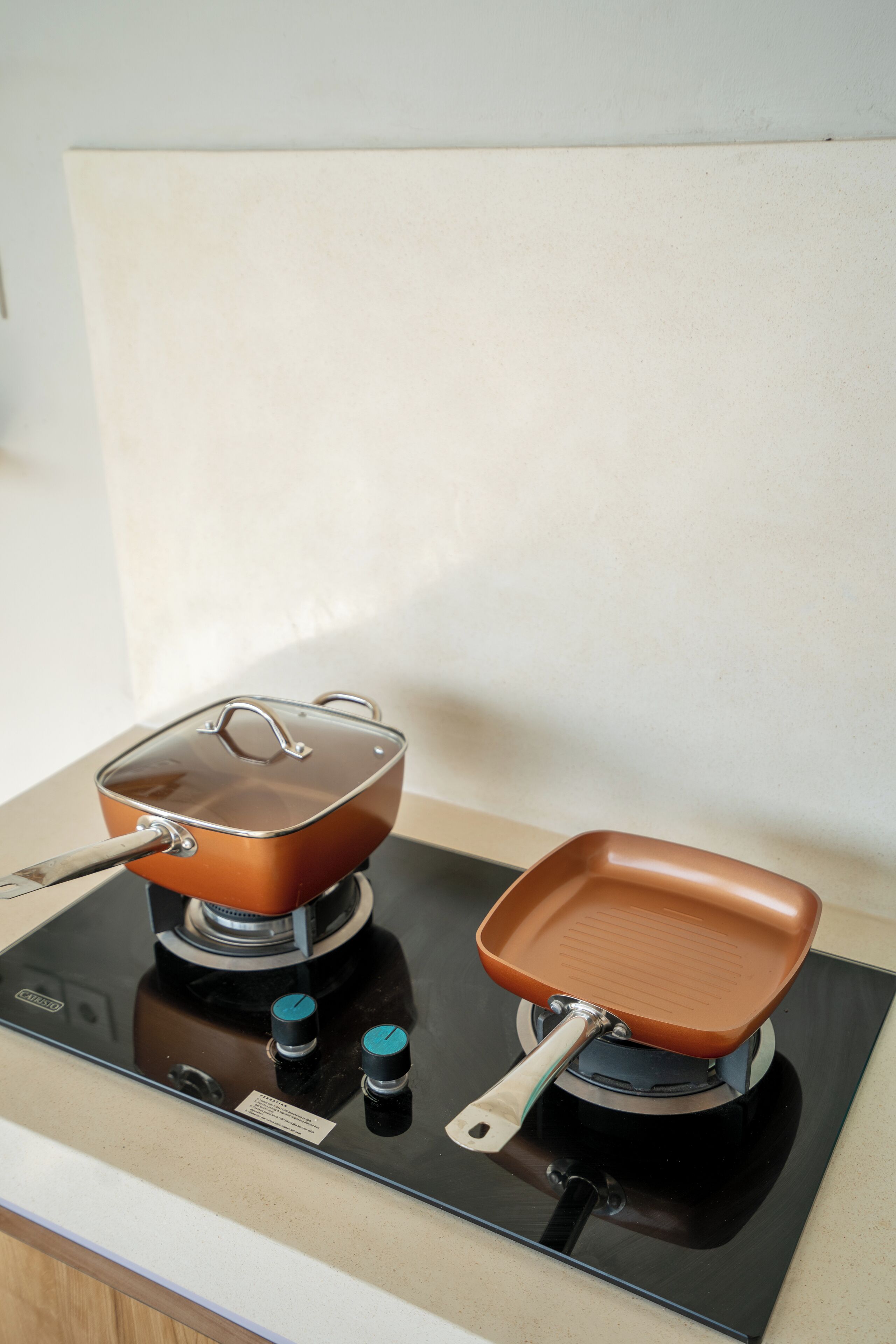 Une cuisine équipée d’une cuisinière, d’une casserole et d’une poêle.