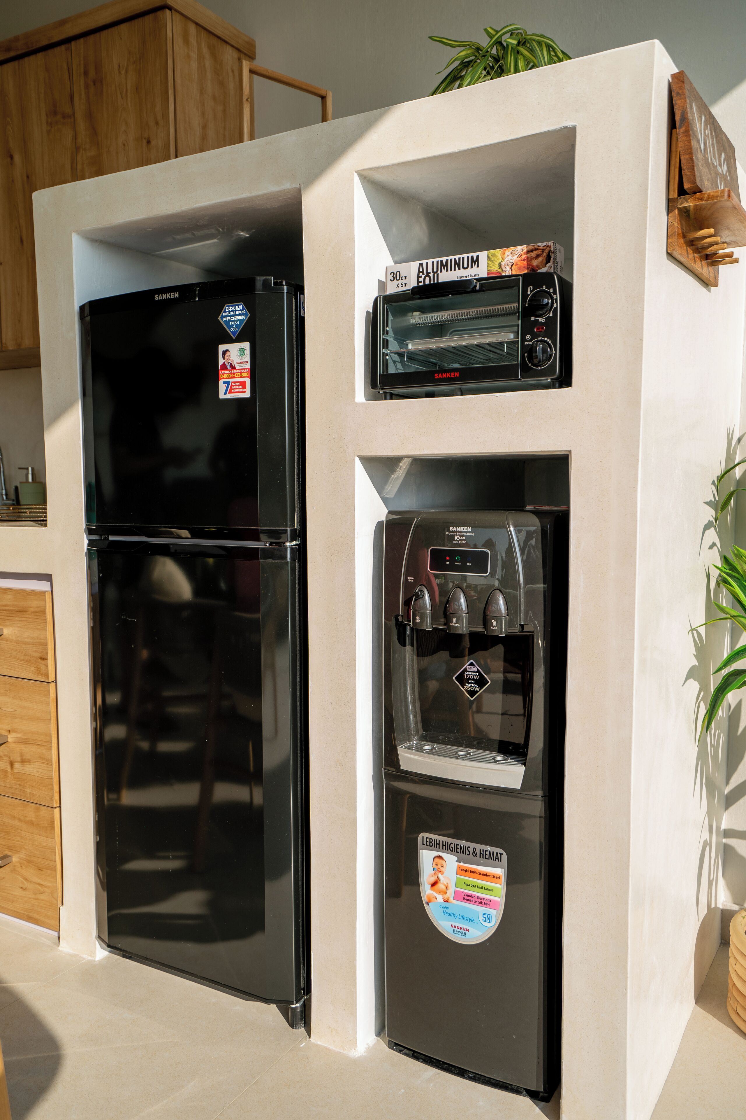 Una cocina con un refrigerador negro, horno empotrado y dispensador de agua.