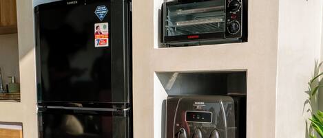 Una cocina con un refrigerador negro, horno empotrado y dispensador de agua.