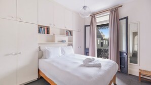 Ein ordentlich eingerichtetes Schlafzimmer mit einem Bett, einem Kleiderschrank und einer kleinen Bank.