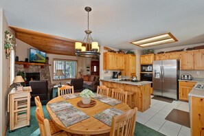 A spacious kitchen with wooden cabinets, a central island, and a stainless steel refrigerator.