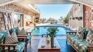A poolside area with a stone wall, seating, and a view of the pool.