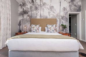 Relax in a spacious room with a large bed, tropical mural, and cozy touches.
