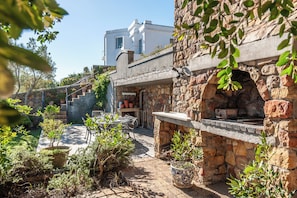 Enjoy al fresco dining on the patio, featuring a grill and seating area.