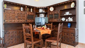 A dining area with a wooden table, chairs, and a television.