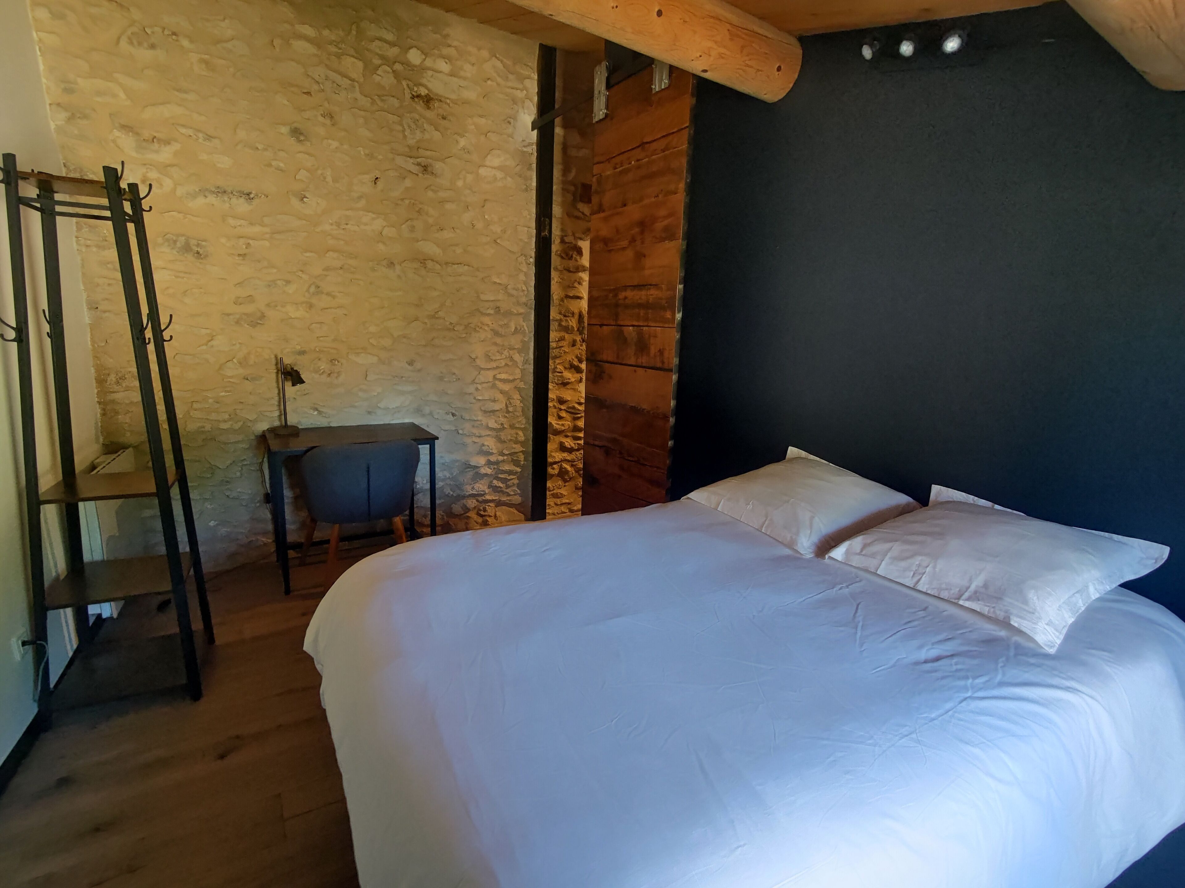 Un dormitorio con una cama grande, un escritorio y una silla.