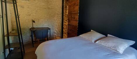 Un dormitorio con una cama grande, un escritorio y una silla.