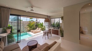 A modern living room with a pool, comfortable seating, and a kitchen area. - Casa Melosa - Charming and Intimate Villa Nestled in Umalas (Kerobokan)