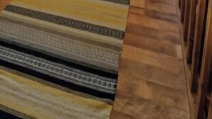 Une chambre mansardée chaleureuse avec un plafond en pente, une lucarne, un lit, une petite table et une chaise.