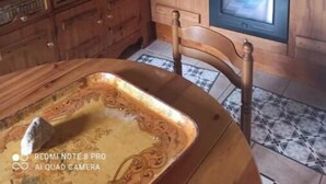 Une cuisine avec des meubles de rangement en bois, une cuisinière, un four et un dosseret carrelé.