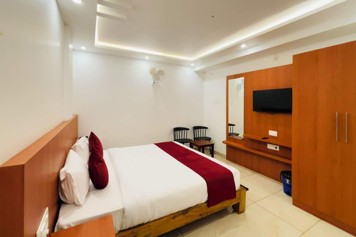 A modern bedroom with a wooden bed, a TV mounted on the wall, and a wooden wardrobe.