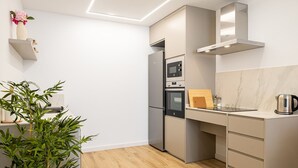 Una cocina moderna con horno integrado, microondas y electrodomésticos de acero inoxidable.