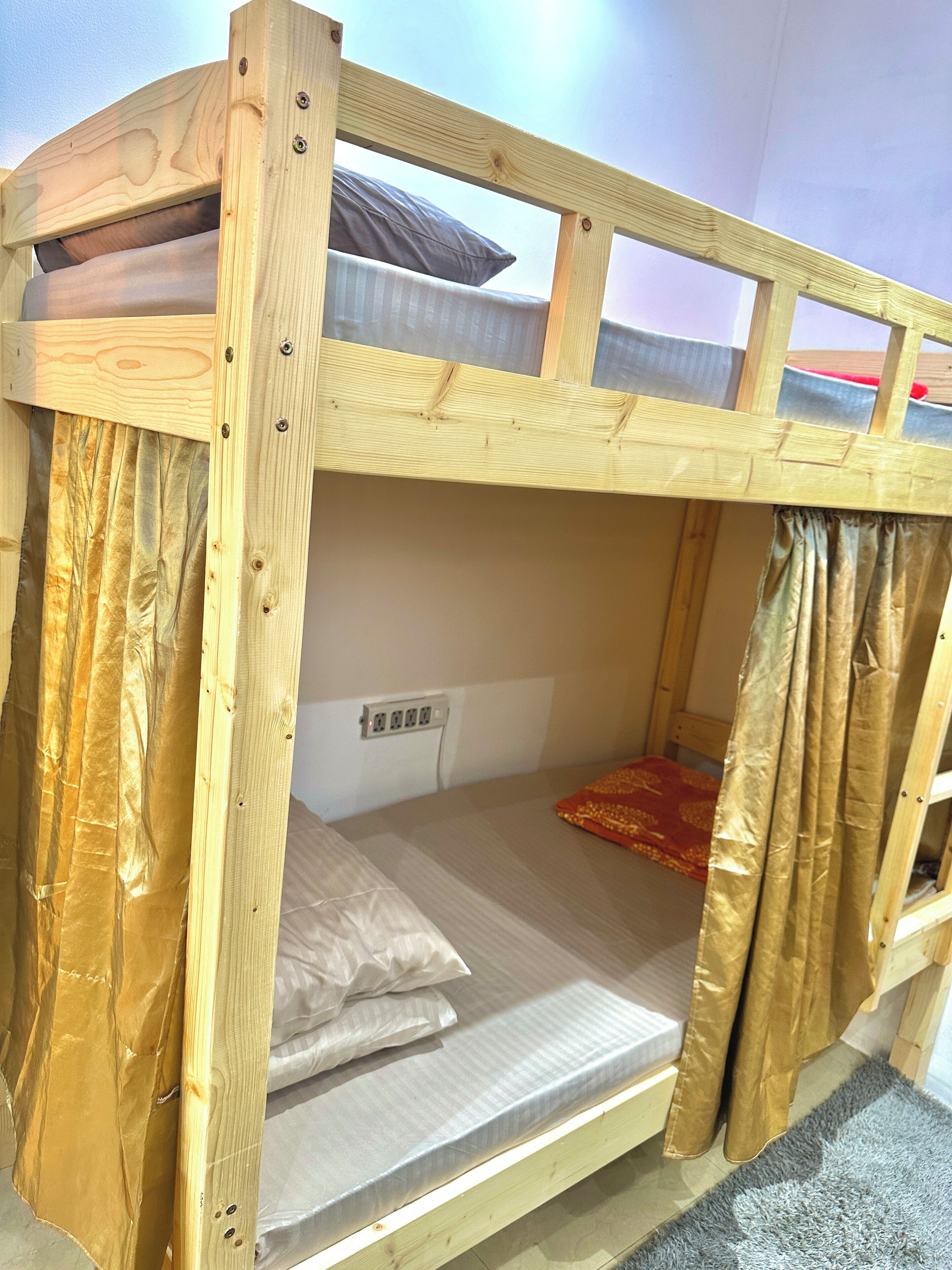 A bunk bed with a wooden frame, a mattress, and a pillow.