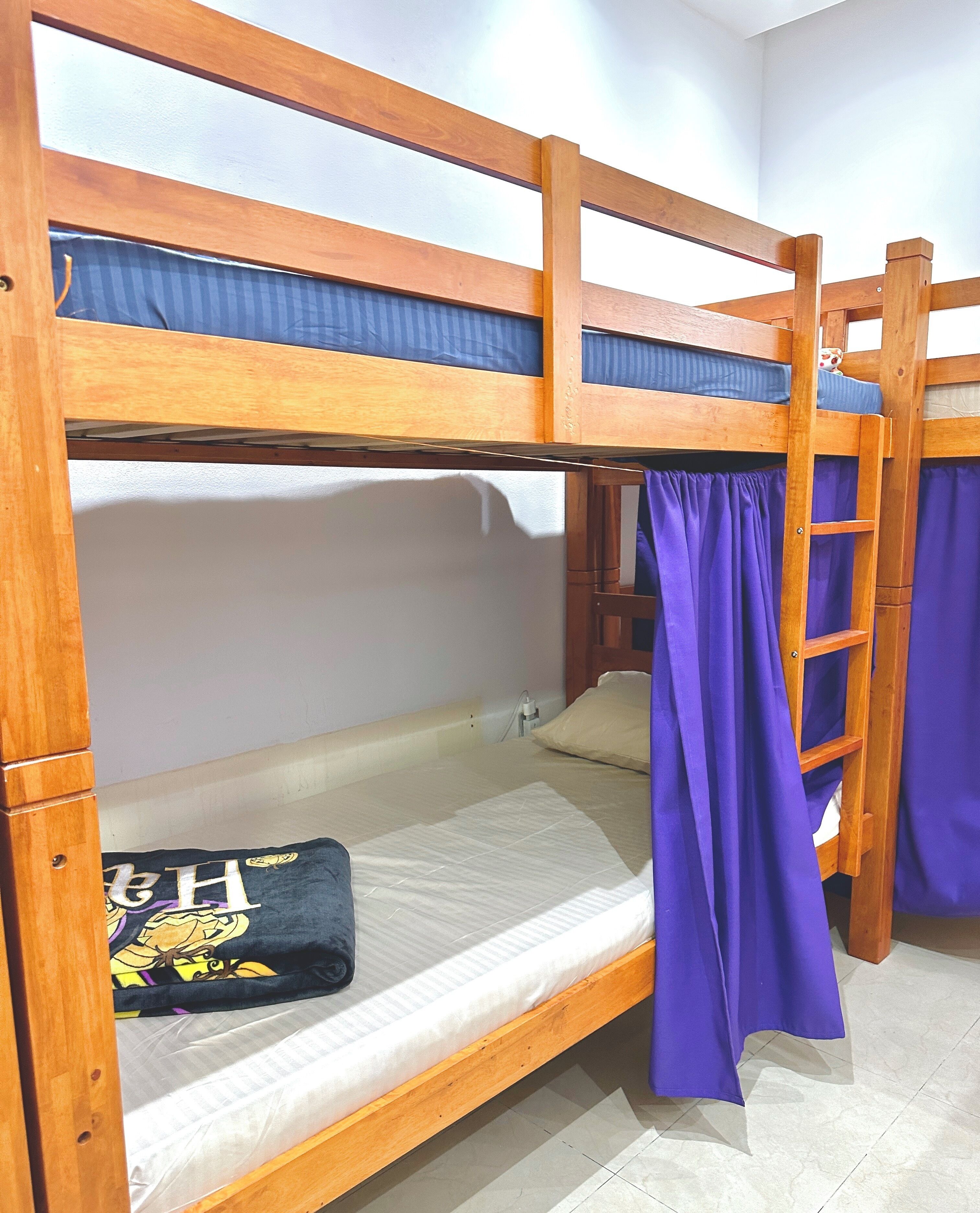 Un lit superposé avec un matelas bleu et un oreiller orné d’un motif graphique.