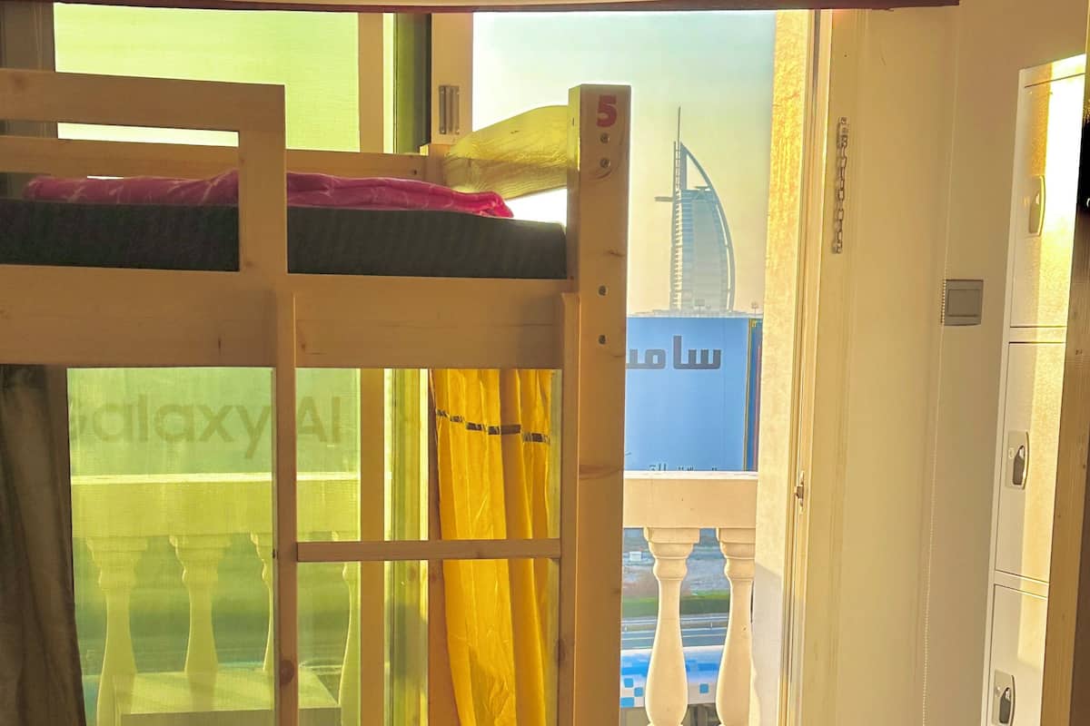A bunk bed with a view of a building outside.