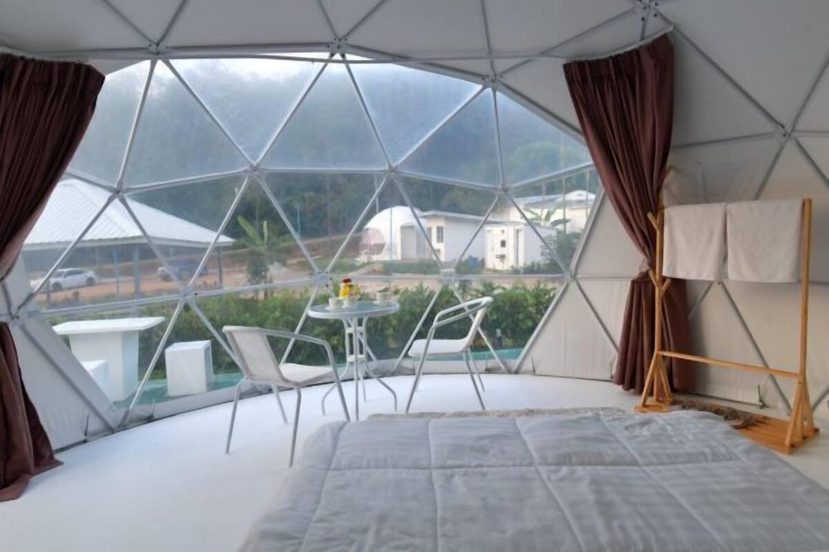 Una habitación abovedada con una cama, una mesa y sillas.