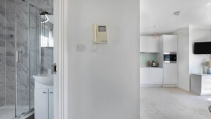 A modern bathroom with a glass shower enclosure, a white sink, and a toilet.