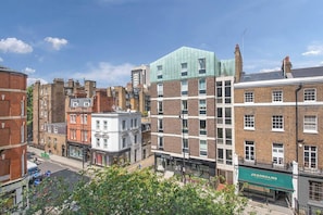 A multi-story building with a mix of brick and modern facades, including a green-roofed structure.