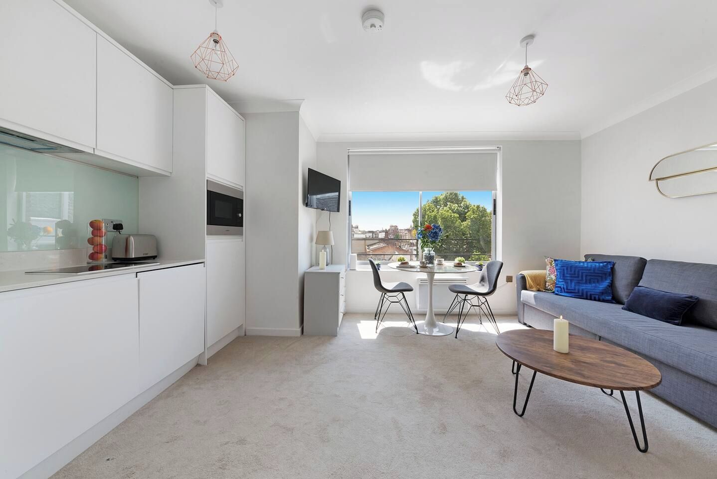 A modern apartment with a kitchen, dining area, and living room.
