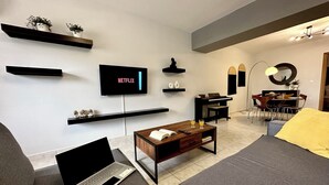 A modern living room with a flat-screen TV, a laptop, a coffee table, and a sofa. - Mylos home (Ierapetra)