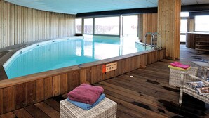 En inomhuspool med väggar och ett däck av trä.