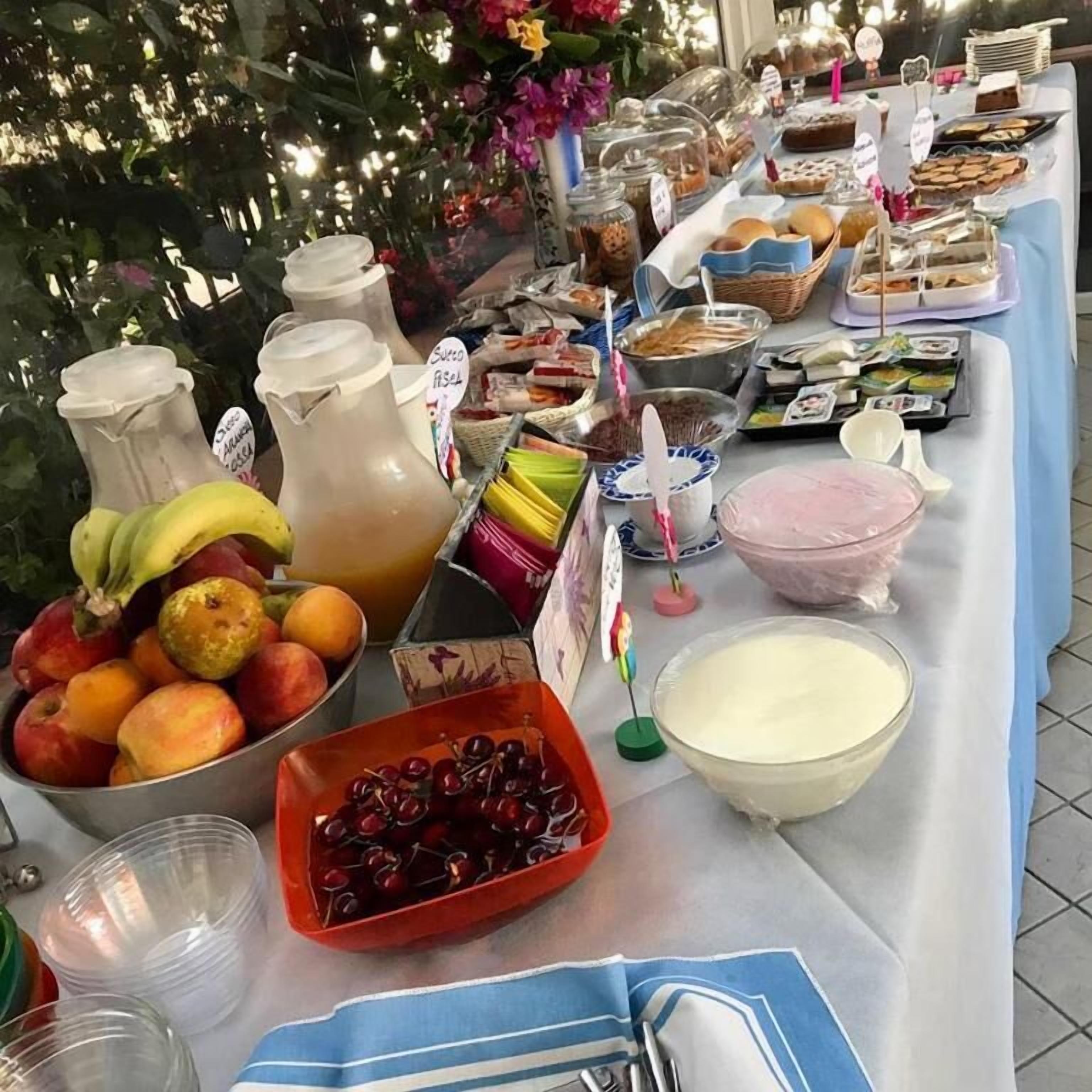 Ein Buffet mit verschiedenen Speisen, darunter Obst, Getränke und Desserts.