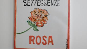 A framed artwork with a rose and text.