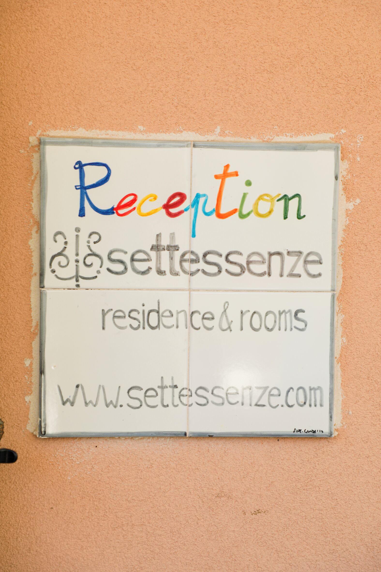 A sign with the words "Reception & Settenzene residence & rooms" and a website address.