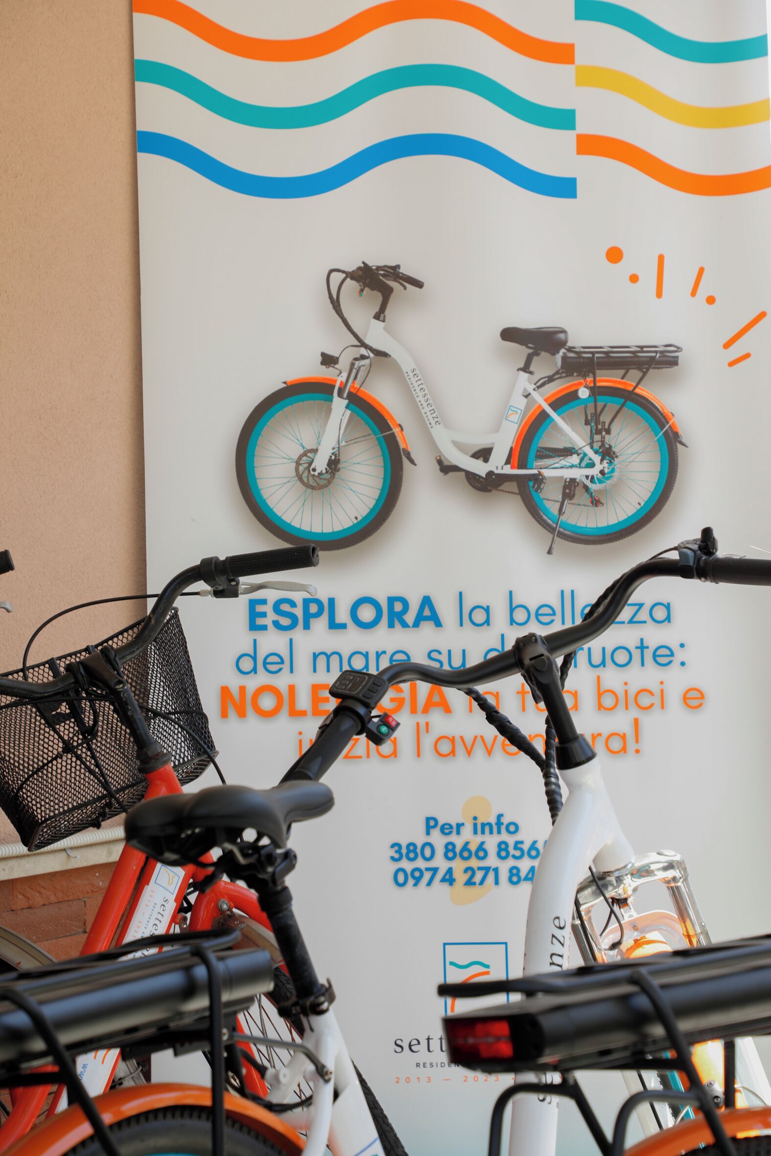 A bicycle parked in front of a wall with a colorful advertisement.