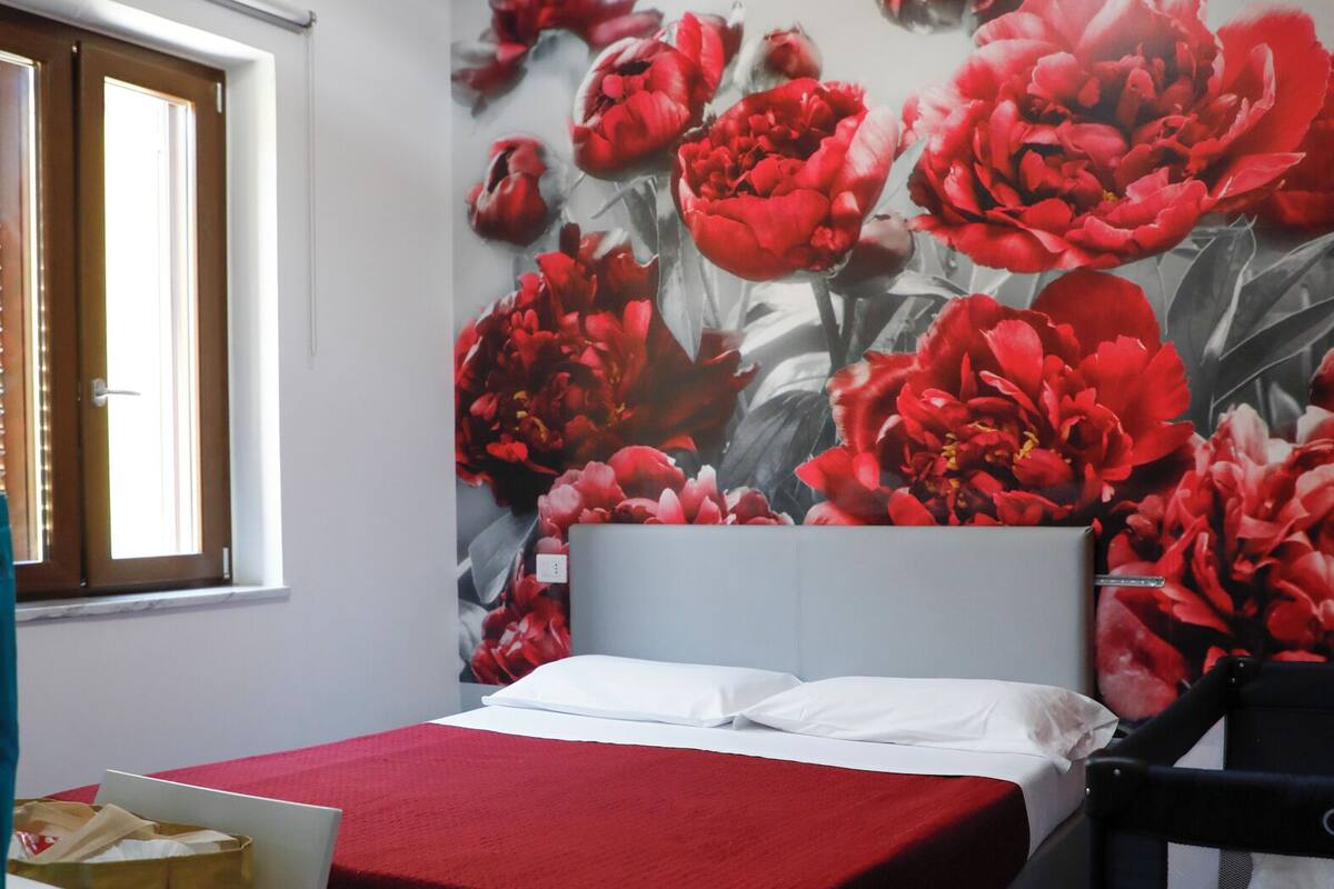 A bedroom with a bed, a window, a desk, and a chair.